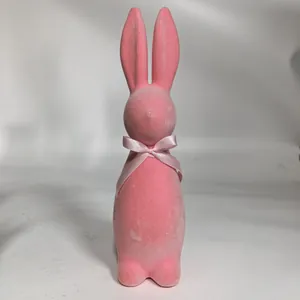 Detailed view of a pink flocked Easter bunny figurine with a decorative silk bow.