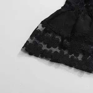 Gros plan sur la dentelle florale noire et le patchwork de tulle d'une robe vintage