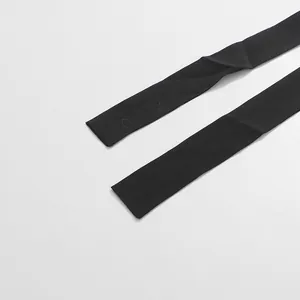 Détail des bretelles en tissu noir d'une robe en dentelle de style français vintage.