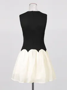 French vintage sleeveless mini dress featuring a black bodice and white ruffled skirt