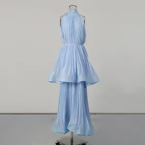 Detail of light blue pleated maxi dress featuring a tiered hem and elegant ruffled collar.