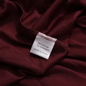 Primer plano de la etiqueta del vestido burdeos con 95 % nailon y 5 % elastano del material