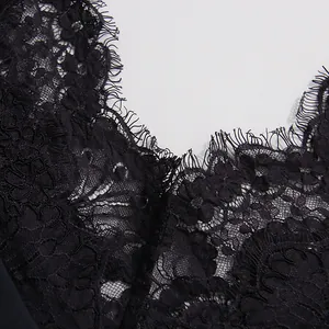 Primer plano de encaje floral negro con ribete de pestañas en un vestido de cuello V.