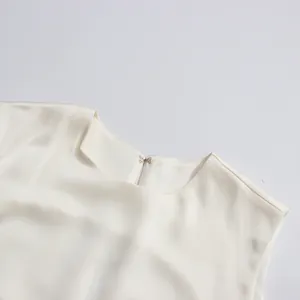Primer plano del cuello de un vestido de seda blanca sin mangas con cierre de gancho fino
