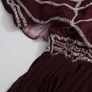 Detalle de pedrería plateada sobre la tela de un vestido plisado de malla burdeos vintage