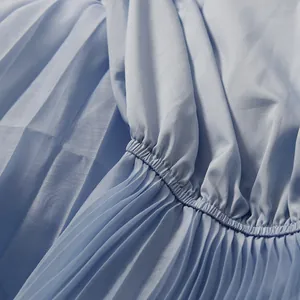 Detailed close-up showing pleated fabric and elastic waist on a light blue dress.