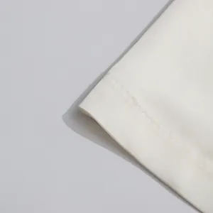Primer plano del dobladillo y las costuras de tela blanca lisa en el vestido sin mangas minimalista