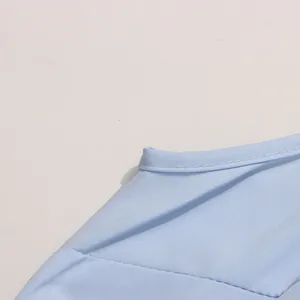 Détail de l'encolure et des coutures sur une robe brodée bleu clair de style français
