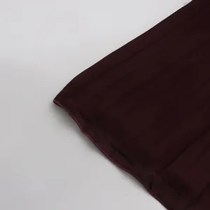 Vista macro detallada que muestra la fina textura y pliegues de la falda larga plisada rojo vino
