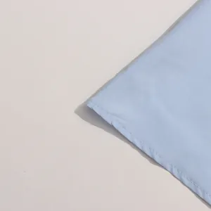 Gros plan détaillé des coutures soignées sur un tissu de robe d'été bleu clair style français.
