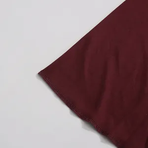 Primer plano del dobladillo cosido de una tela de vestido largo plisado burdeos