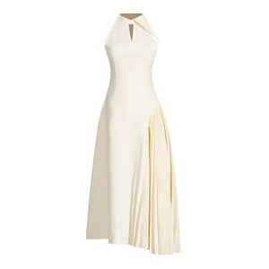 Detailed view of white asymmetric pleated hem and halter neckline on a maxi dress