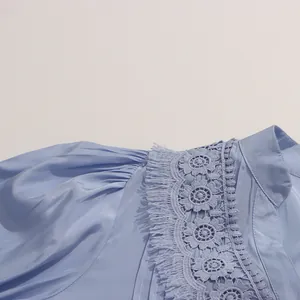 Détail de la broderie ajourée sur une manche de robe bleu clair de style français.