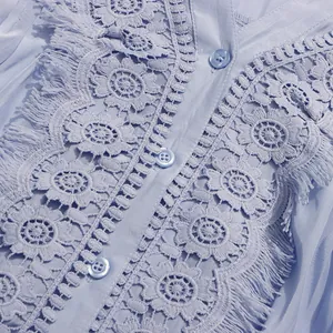 Vue détaillée des broderies florales complexes et des franges sur une robe d'été bleu clair