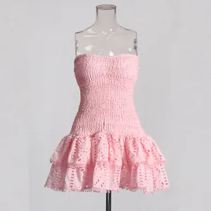 Gros plan d'une robe rose bustier à smocks avec un ourlet à volants et broderie anglaise