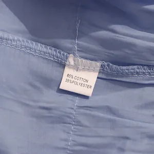 Gros plan détaillé de l'étiquette de composition montrant 65 % coton et 35 % polyester
