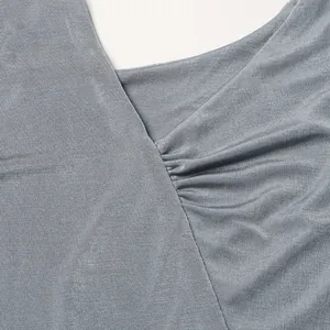 Dettaglio del tessuto in maglia grigio-blu e del design a pieghe di un abito aderente