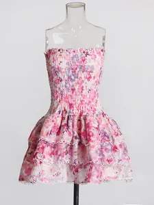Detailed view of floral strapless dress with smocked bodice and ruffled lace edges.