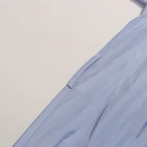 Gros plan sur la poche latérale et la texture du tissu d'une robe longue bleu clair.