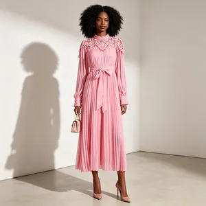 Robe midi plissée rose élégante avec col montant en dentelle et nœud à la taille.