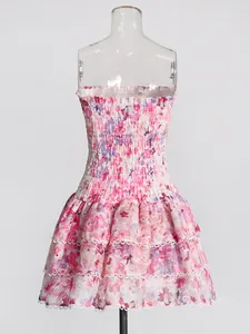 Detailed view of floral smocked bodice and ruffled lace hem on pink bohemian dress