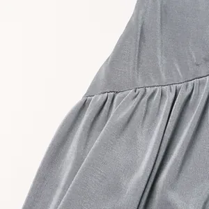 Dettaglio del tessuto in maglia grigia elastica con elegante trama a pieghe su un abito lungo