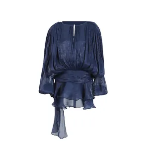 Detailed view of the navy blue pleated fabric and ribbon tie on this elegant dress