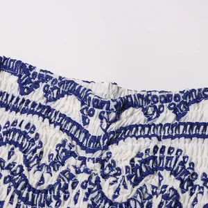 Macro view of elastic smocked bodice with intricate blue bohemian embroidery details