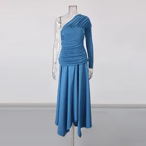 Detail showing gathered pleats and asymmetrical hem of blue one-shoulder maxi dress