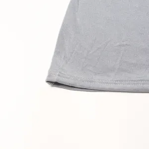 Dettaglio ravvicinato delle cuciture sottili e dell'orlo di un abito in maglia grigio elastico