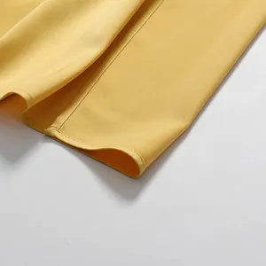 Detailopname van de zoom en het fijne stiksel van een elegante gele formele avondjurk