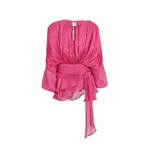 Detailed view of vibrant pink loose long sleeve dress featuring waist tie and flowing ribbons