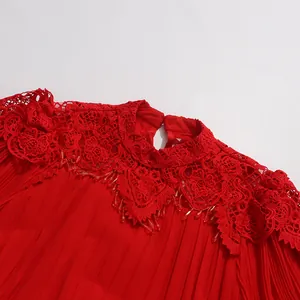 Vue détaillée d'une robe rouge élégante avec col montant en dentelle et perles suspendues