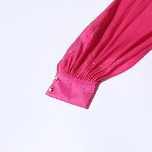 Macro view of bright pink pleated dress sleeve with exquisite pearl button cuffs