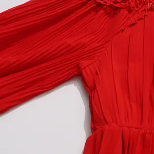 Vue rapprochée d'une robe plissée rouge vif avec une bordure en dentelle élégante