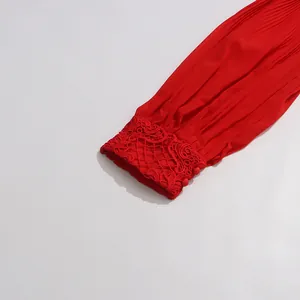 Vue détaillée de la manche d'une robe plissée rouge avec broderie en dentelle élégante