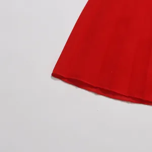 Gros plan de l'ourlet d'une robe plissée rouge vif montrant des coutures de qualité