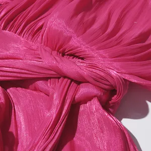 Macro detail of pleated fuchsia fabric with a twist knot design for women's dress
