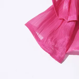 Macro detail view of pink pleated fabric texture with fine stitching on dress sleeve.