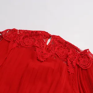 Gros plan sur le col en dentelle rouge élégant et la texture plissée d'une robe.