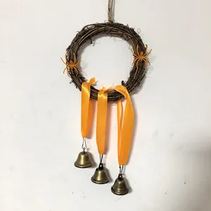 Detail des Halloween-Rebenkranzes mit orangefarbenen Bändern, Spinnen und Metallglocken.