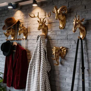 Vue détaillée des crochets muraux créatifs en tête d'animal dorée sur mur de brique