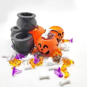 Detalle de mini cubos de calabaza de Halloween y calderos con accesorios para fiestas.