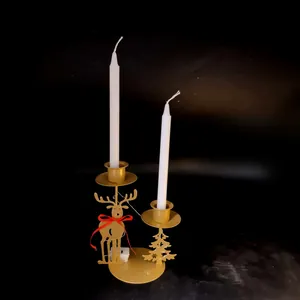 Detailed view of golden iron Christmas reindeer candle holder with white candles