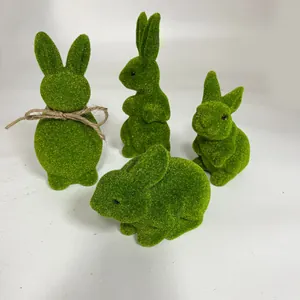 Detailed view of four green flocked moss Easter bunny figurines for desktop decor