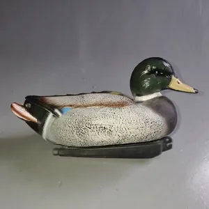 Detailed side view of a realistic plastic mallard duck decoy for garden pond decor
