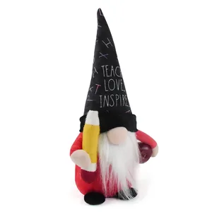 Detailed view of a teacher gnome plush doll holding a plush pencil and a red apple.