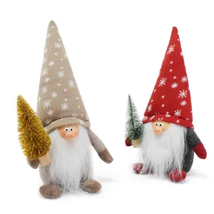 Detail view of two Christmas gnomes with resin faces holding gold and green trees