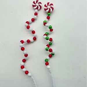 Detail of festive Christmas candy cane spiral picks with red and white beads