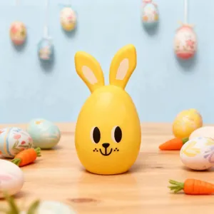 Detail shot of a cute yellow Easter bunny egg candy container on a festive table